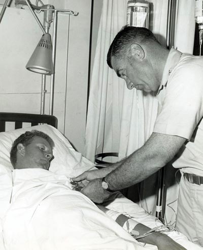 A2C Davis, Lyle K., AF14861942 wounded in action on 4 Dec 1966, is being presented the Purple Heart at U. S. Army 3rd Field Hospital by Col Grover K. Coe, Tan Son Nhut's Base Commander.