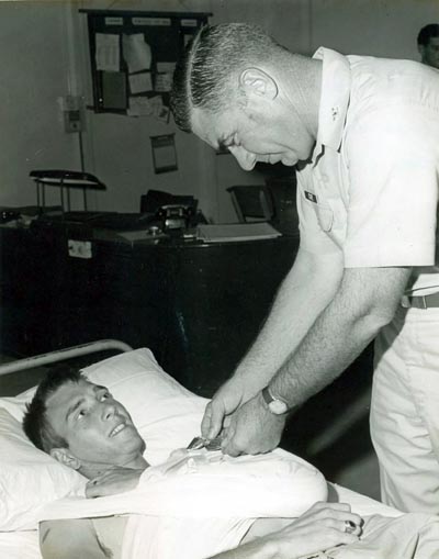 A2C Throneburg, Robert A., wounded in action on 4 Dec 1966, is being presented the Purple Heart at U.S. Army 3rd Field Hospital by Col Grover K. Coe, Tan Son Nhuts Base Commander.
