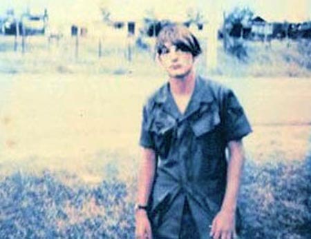 Photo by Danny Wilson, 1972-73 :Paul Huff waiting for a pass to Saigon. Road leads to the Biên Hòa's Main Gate. Village in the background. I am pretty sure there were a few V.C. living there who worked for us during the day, and were out for blood at night.