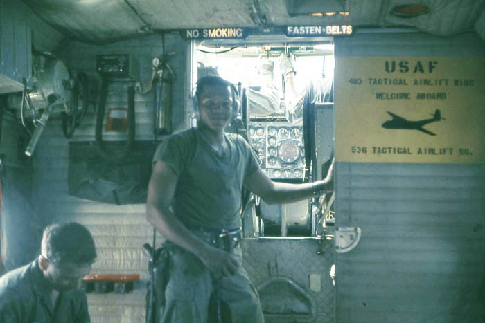 Bien Thuy Air Base flight line. Australian Caribou STOL taxies. Crew with cockpit view. Sign Reads: USAF 483rd Tactical Airlift WIng. Welcome Aboard. 536th Tactical Airlift Squadron. MSgt Summerfield: 11