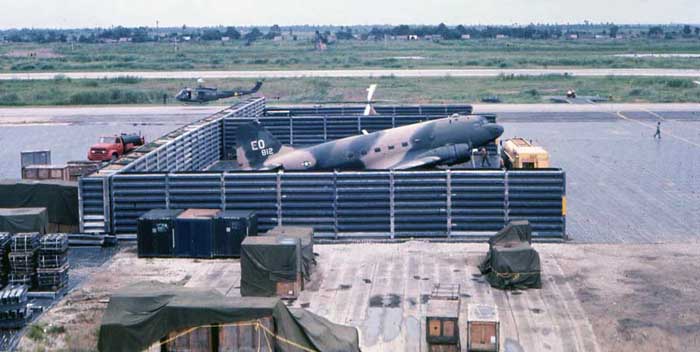 Bien Thuy Air Base flight line C-47 revetment, with Chu Hoi bird. Huey parked next door with one sliding along apron behind. MSgt Summerfield: 17