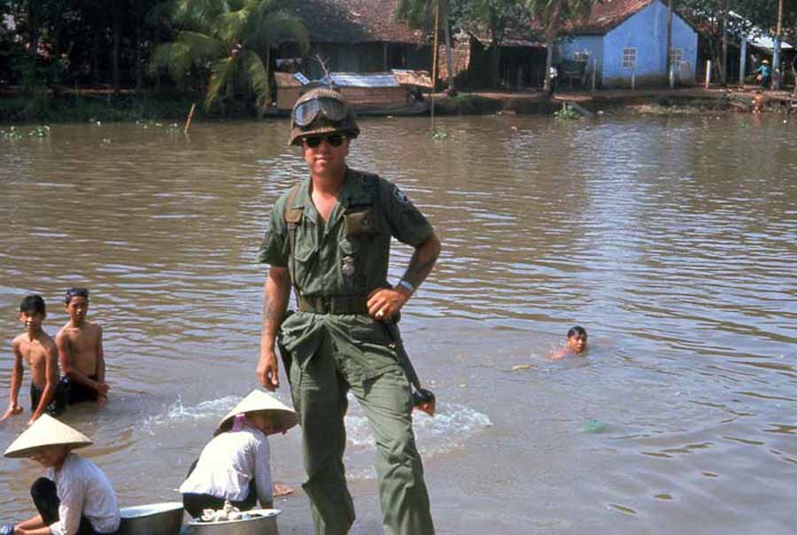 Bien Thuy Air Base. Mamasan do washie-clothes while kids swim. MSgt Summerfield, 1968: 06