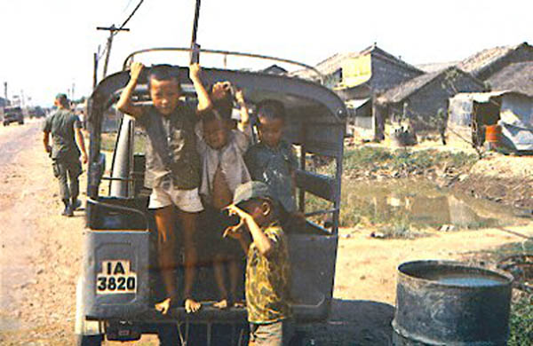 62) Hey Joe! Kids on back of 3-wheel cart-truck.