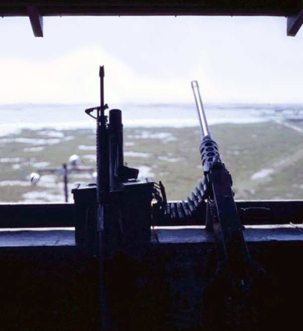 4. Cam Ranh Bay AB. Perimeter Tower view. M-16 and .50-Cal on the counter. Floodlights (foreground) illuminate the marsh and shore. 1970. Photo by: Jim Randall, LM 69, CRB, 483rd SPS, 1970.