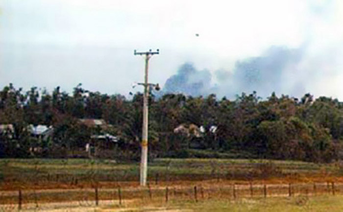 7. Đà Nẵng Air Base: Airstrike as viewed from East perimeter. Dog Patch village in fore ground of trees and jungle. No Man's land between village and wire. Farmers and kids occassionally wondered in the area alone or with water buffalo grazing. Trees were cut back and defoliated for a clear fire zone. Photo by Alan Ellison, 1968.