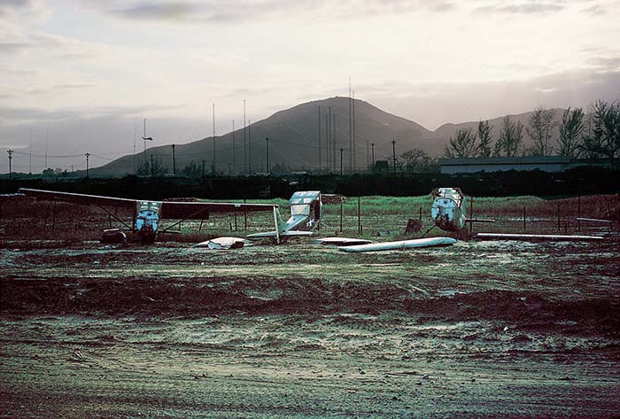 1965 Đà Nẵng AB, South Vietnam: O-1E Birddog aircraft boneyard.  View outside the read of my tent.  Don Poss