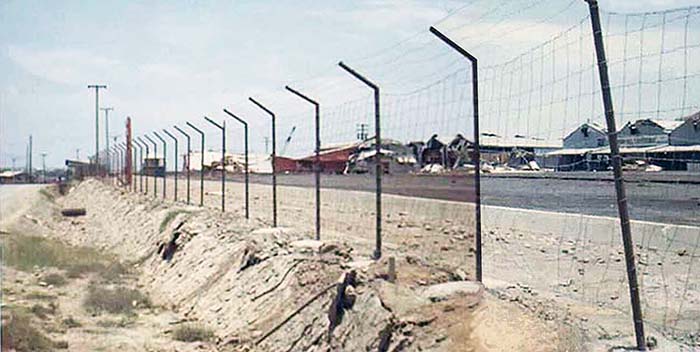 5. Đà Nẵng AB, 366th SPS. Perimeter fence cutting through civilization. Rocket damaged structures center-right. Photo by: James Paul Mashburn 1966-1967.