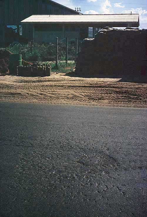 10. Đà Nẵng AB, Tent City: POL road's patched mortar crater within yards of POL AP post. 1966.