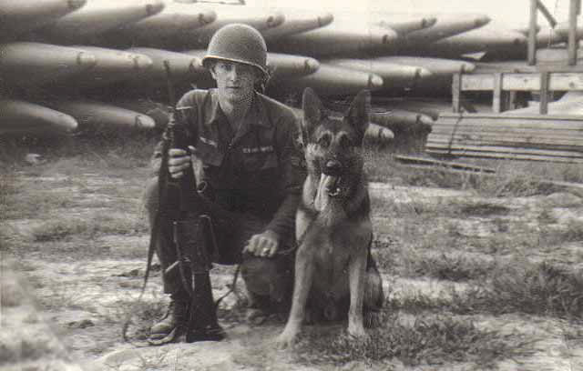 15. Đà Nẵng AB, K-9 Growl Pad: Airman awaiting K-9 Trailer. Wing Tanks stored on Growl Pad grounds. 1965.