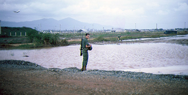 21. Đà Nẵng AB, K-9 Growl Pad: A1C Al Watts watches Blackie to make sure new handler Don Poss does not screw up Blackie's instructions. 1965.