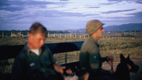 24. Đà Nẵng AB, K-9 Growl Pad: Posting Truck circles airbase perimeter road, dropping of K-9 handlers and dogs. 1965.