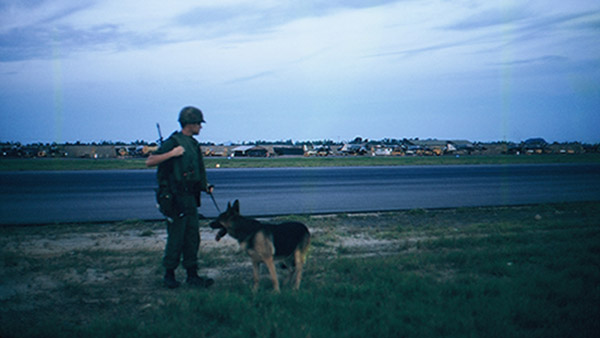 26. Đà Nẵng AB, K-9 Growl Pad: Don Poss and Blackie have just completed first-sweep of post west of only active runway. 1965.
