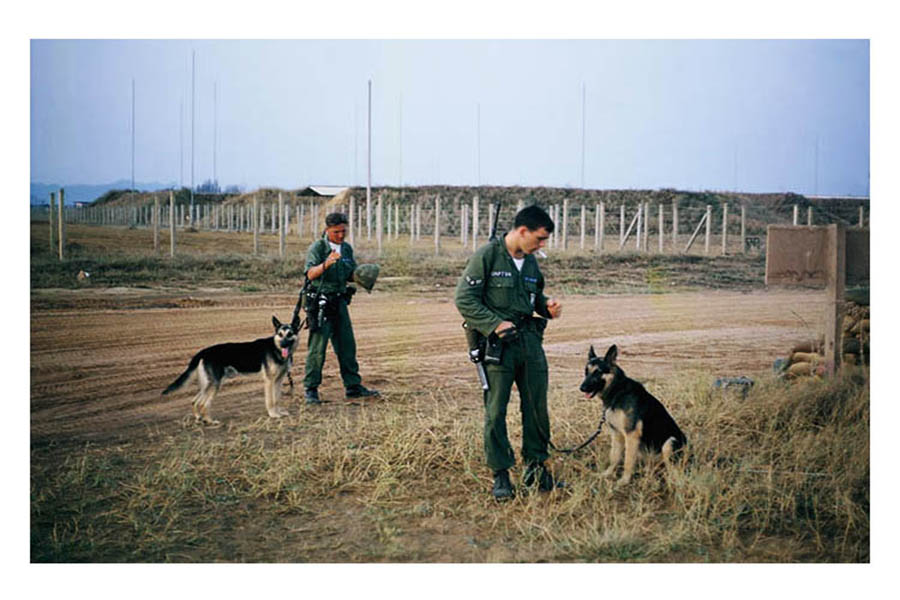 32. Đà Nẵng AB, K-9 Growl Pad: K-9 handlers grab a last-smoke break before entering the Ammo/Bomb Dump for post patrol. 1965.