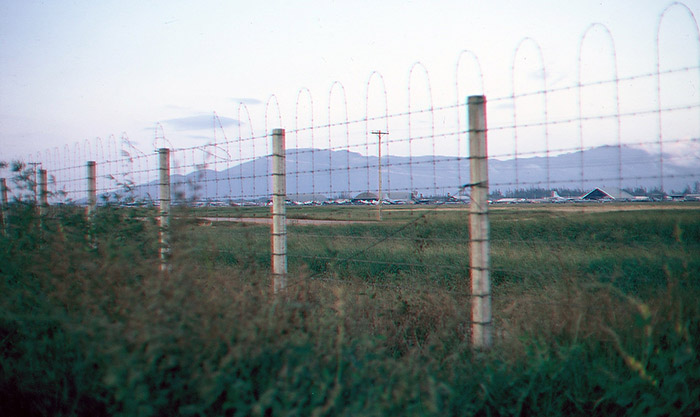 45. Đà Nẵng AB, K-9 Growl Pad: Air Base flight line is visible through the Ammo-Bomb Dump perimeter fence. 1965.