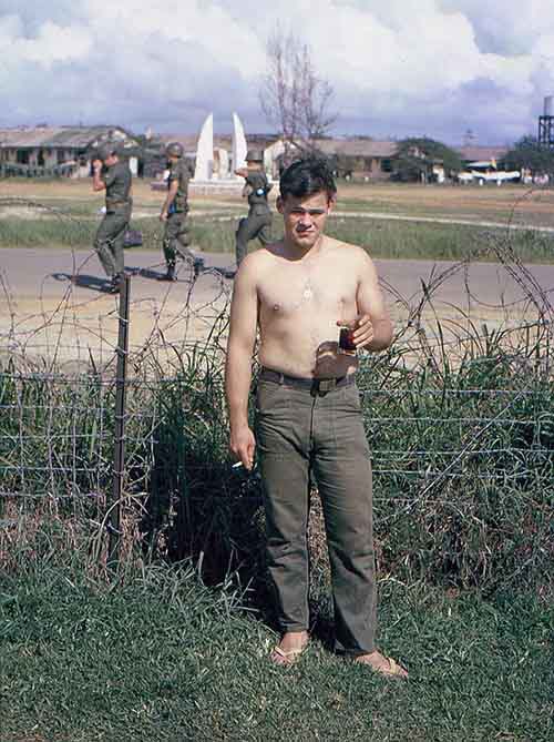 21. Đà Nẵng AB, Tent City: James McNall takes a break from the tent's heat. From my tent compound, We had watched construction of the ARVN Uplifted Wings Memorial for a few weeks, which was pretty fast considering the bureaucracy necessary to accomplish anything. 1965.