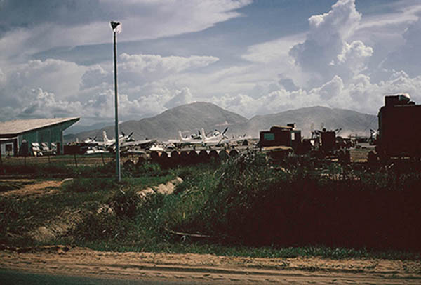 25. Đà Nẵng AB, Tent City: Looking west from the west cantonment's AP Access post, you could see Freedom Hill 327 in the near distance (about five miles). You would look across the VNAF A1E aircraft parking area. 1965.