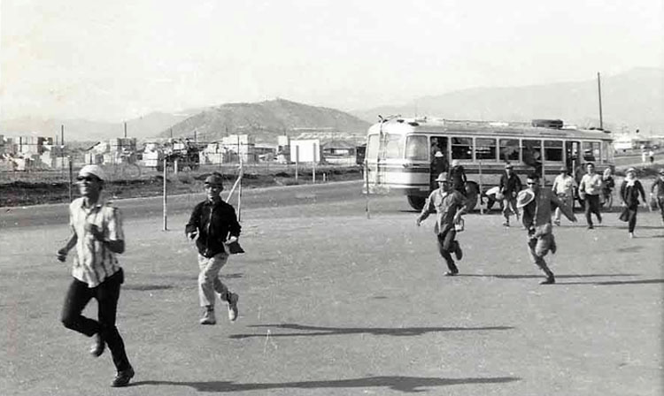 12. Nui Dat: Civilian Vietnamese workers running to work frombus. Photo by Dana Anthony, ND 1969. 