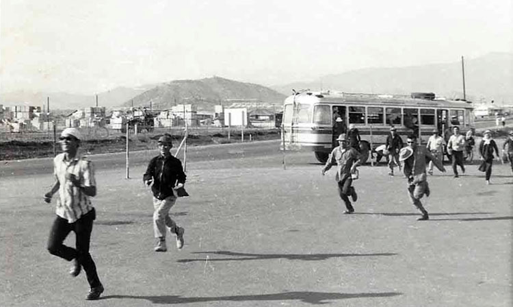 12. Nui Dat: Civilian Vietnamese workers running to work frombus. Photo by Dana Anthony, ND 1969. 