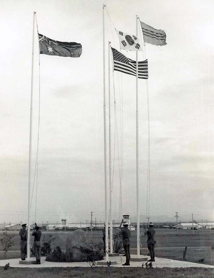 13. Nui Dat: Australian Base. Allied troops raise national flags. Photo by Dana Anthony, ND 1969.