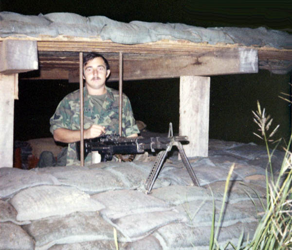 10. NKP RTAFB: A1C Jim Allen at bunker, behind fence. Photo by Wilfred Wright. 1971.
