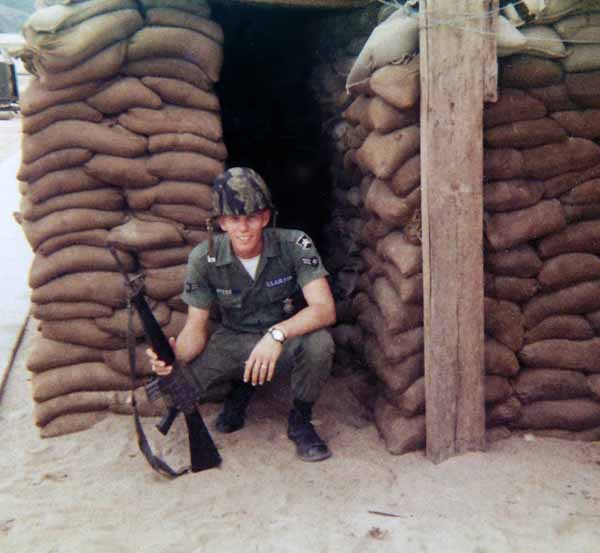 Photo #11 (Nha Trang): This is me getting ready to go on duty. I must have been assigned to the Main Gate as I don't recall helmets being worn on any other post. This was taken behind the hooches prior to the move to the concrete barracks. At the time of this photo we maintained our weapons in the hooches.