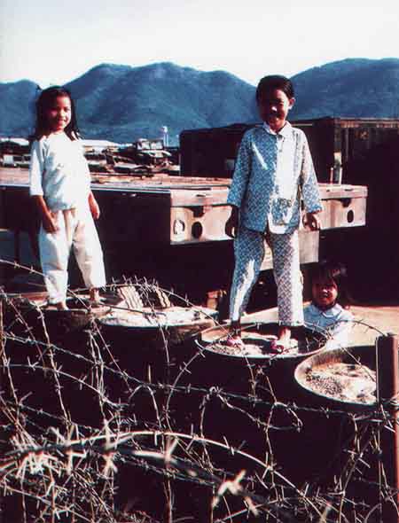 3. Nha Trang Air Base: Children playing on barrels, trailers, and containers. Photo by Phil Lange, 1968-1969. 