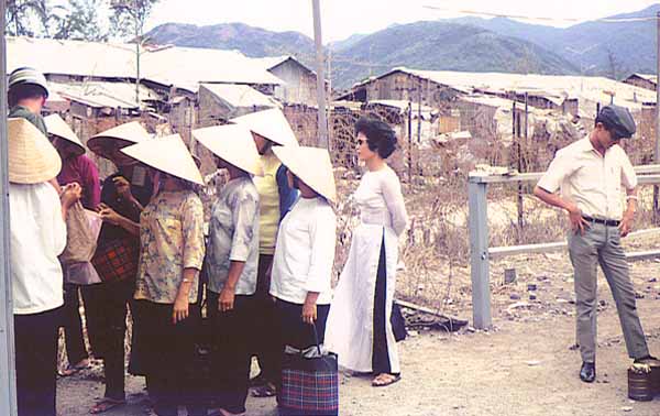 14. Nha Trang AB Gate Post-4. Entry/Exit for Civilian Vietnamese workers.Women go thru the shack and are searched by a Chinese female. Vietnamese man waiting to be searched when leaving. Photo by: Tony Niemotka, LM 577, NT, 14th SPS, 1968-1969.
