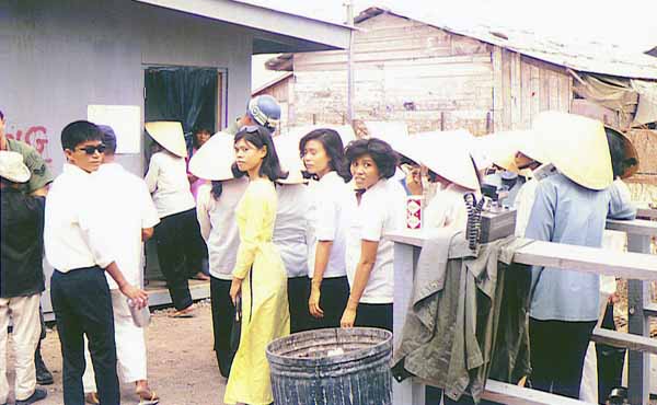 15. Nha Trang AB Gate Post-4. Civilian Vietnamese women go thru the shack and are searched by a Chinese female (Happy in their work?). Vietnamese man waiting to be searched when leaving. Photo by: Tony Niemotka, LM 577, NT, 14th SPS, 1968-1969.