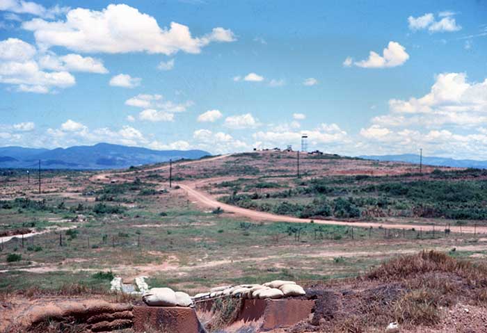 22. Standing on the west shoulder of the runway, looking west toward the Army outpost on the rise. Photo by Don Bishop. 1969-1970.