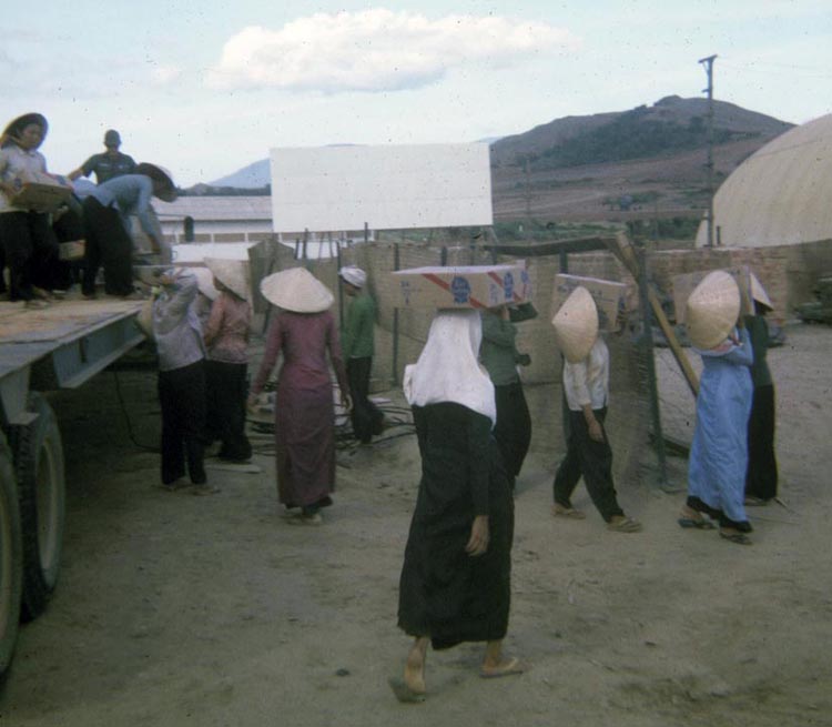 15. Phan Rang Air Base: Vietnamese women workers unloading Pabst Beer (new in 1966: no opener needed!). Note the base theatre's open screen (center), and top right you can see the beer's temporary destination, an inflatable warehouse.