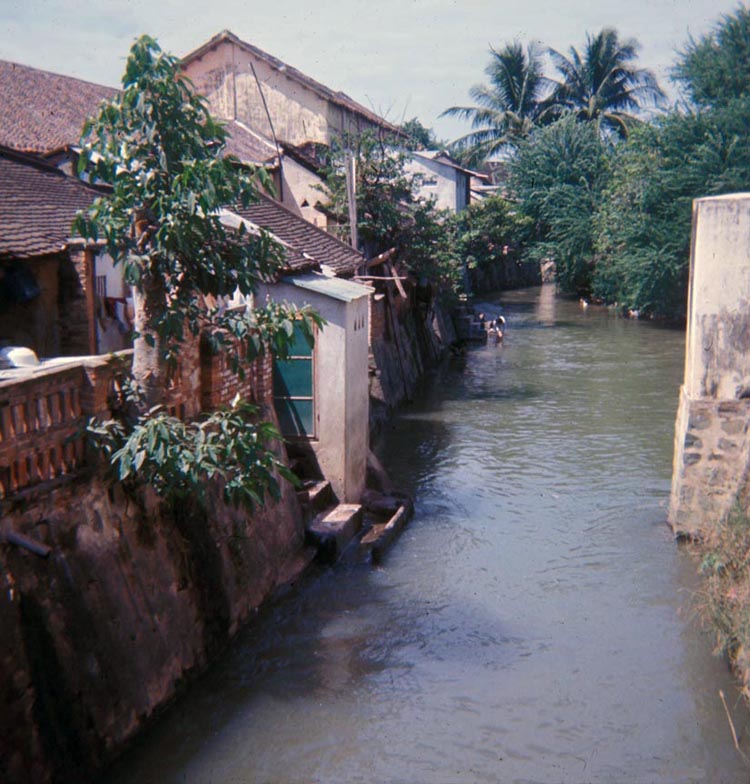 81. Thap Cham river flows through village. Note mamasan scooping water. Fish, washie clothes, drinking water, sewer.