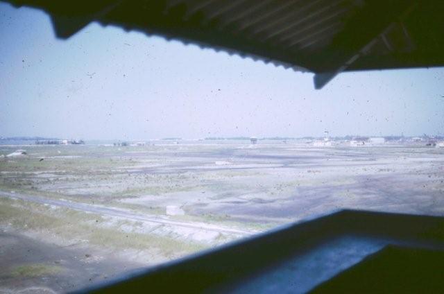 25. You can see another guard tower in the distance and a bunker to the left. This is looking to the northeast from the rear tower. As you can see, from this rear tower, you can see the whole area and that is why there was only one Security Policeman in the tower on day shift and that it was the only tower manned on day shift. The cement block that you see in the foreground was used for the cable anchors for the tower. 