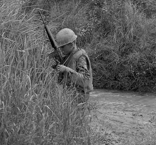 13. USAF SP crosses stream, searching for VC and NVA sappers. 600th Photo Squadron, Vietnam.