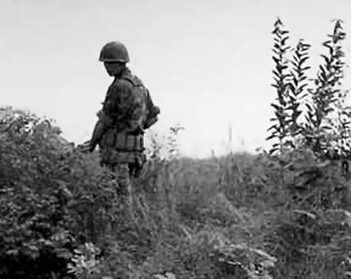 12. USAF SP stands guard as patrol crosses stream. Photo below: 377th APS Airmen prepares to cross another stream, searching for VC and NVA sappers. 600th Photo Squadron, Vietnam.