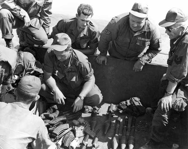 17. Photo right: Major and NCOs examine VC/NVA weapons cache. 600th Photo Squadron, Vietnam.