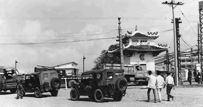 5. TSN Air Base: Main Gate. Jeeps and civilian workers line up to enter airbase. Photo by Roy F. Martin Jr.