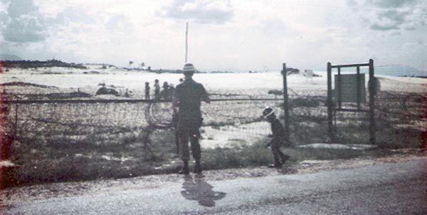 9. Tuy Hoa Air Base: Batman plays around SP, wearing smaller SP helmet, as other children play in field. Photo by Sgt deWhite. 1969-1970.