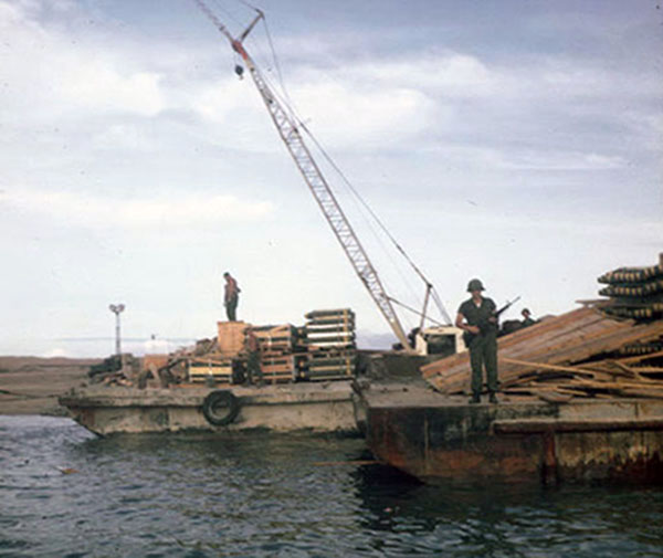 9. Tuy Hoa Air Base: 31st SPS, SP stands guard as bombs are unloaded. Photo by Ed Barker. 1966-1967. 